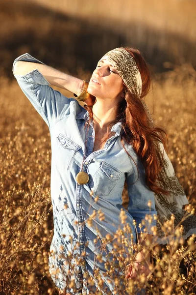 Mooie vrouw op een veld in de zomer — Stockfoto