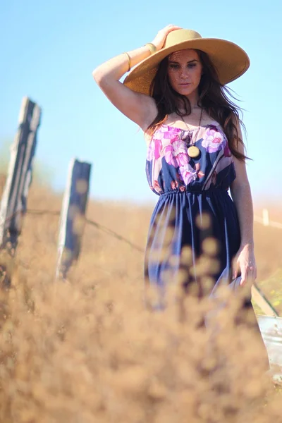 Mulher bonita nova em um campo na hora do verão — Fotografia de Stock