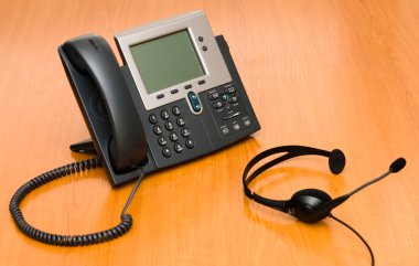 VoIP phone with a headset clipart