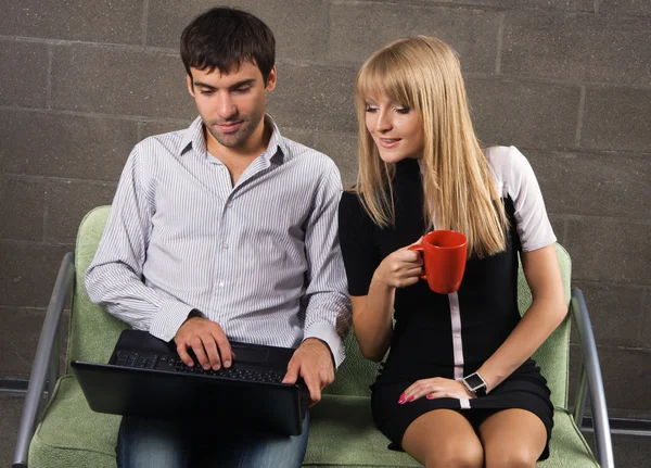 젊은 남자와 여 자가 노트북으로 앉아 — 스톡 사진