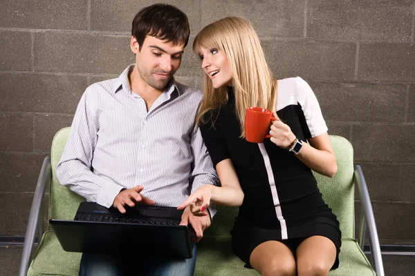 年轻的男人和女人坐在一台笔记本电脑 — 图库照片