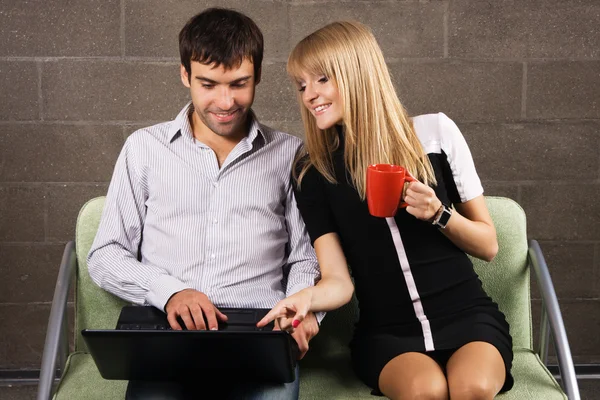 Веселые мужчина и женщина работают с ноутбуком — стоковое фото