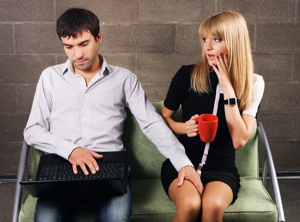 Joven hombre y mujer trabajando con un ordenador portátil — Foto de Stock