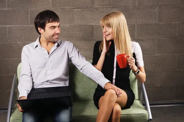 Młody mężczyzna i kobieta siedząca z laptopem — Zdjęcie stockowe
