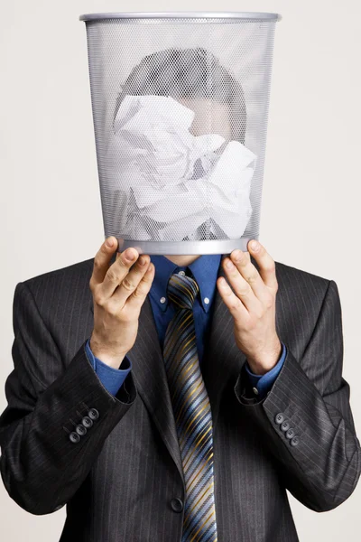 Joven sosteniendo un cubo de basura contra su cabeza —  Fotos de Stock