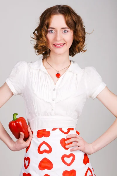 Unga vackra kvinnan håller ut en paprika — Stockfoto