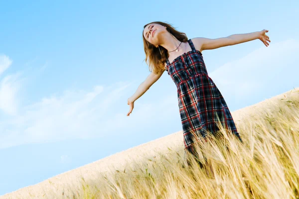 Красивая женщина в клетчатом платье в поле — стоковое фото