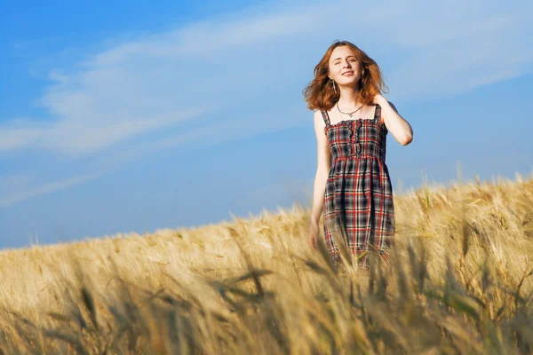 Schöne Frau im karierten Kleid auf einem Feld — Stockfoto