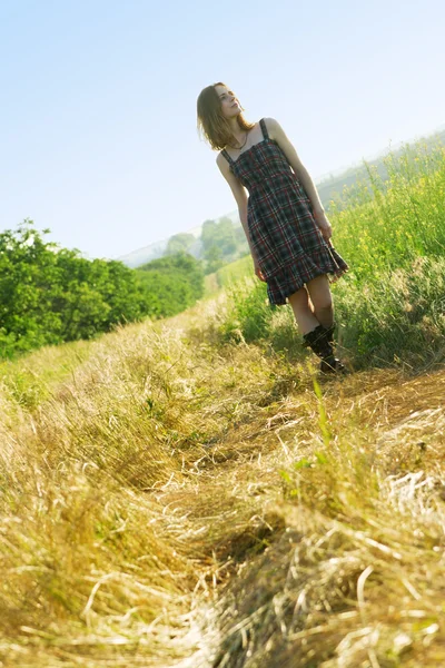Beautfiul mujer en vestido a cuadros en un campo — Foto de Stock