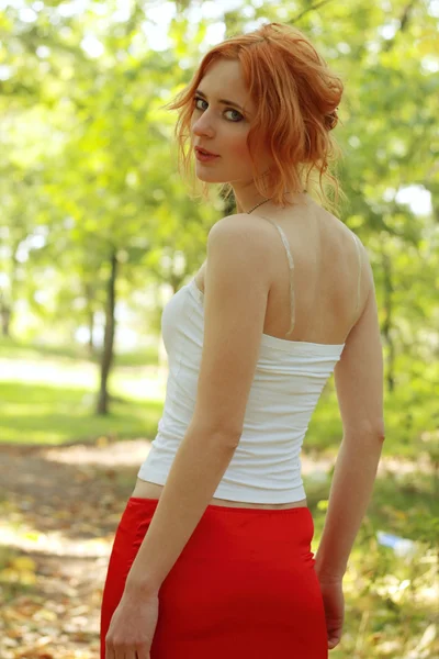 Beautiful young woman in a park — Stock Photo, Image