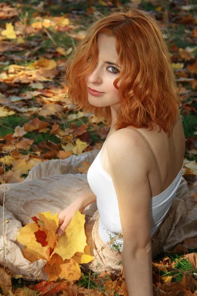 Красивая женщина в желтых листьях — стоковое фото
