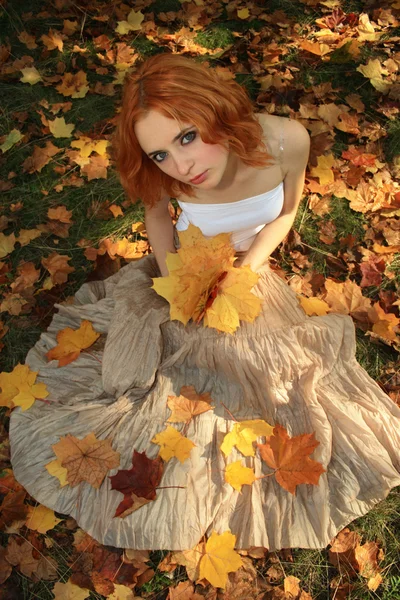 Romantic photo of a young woman in yellow leaves — Stock Photo, Image