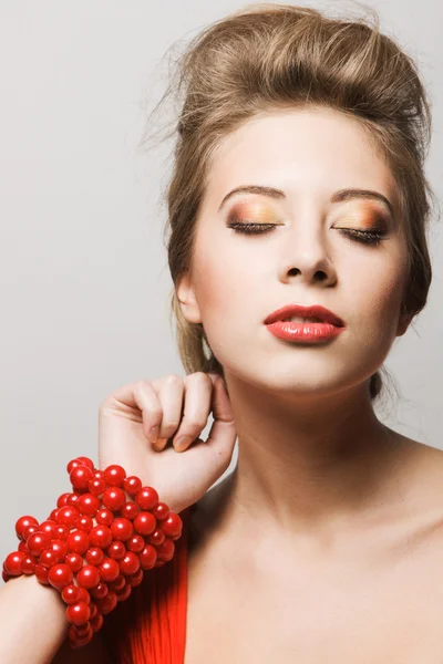 Prachtige jonge vrouw met een rode armband — Stockfoto