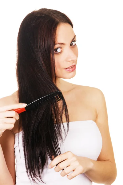 Beautiful young woman combing her hair — Stock Photo, Image
