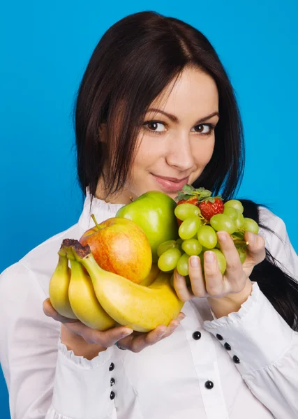 Menina bonita com um monte de frutas — Fotografia de Stock