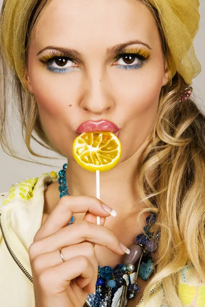 Fashionable young woman holding a candy — Stock Photo, Image