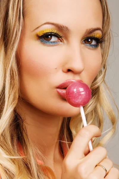 Piękna kobieta z kreatywnych makijaż trzyma cukierek — Zdjęcie stockowe