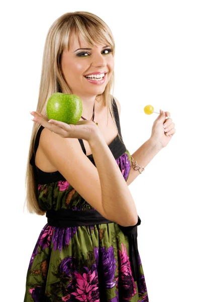 Cheerful young woman holding fresh apple and lollipop — Stock Photo, Image