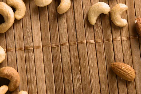 Nüsse auf Bambus Hintergrund — Stockfoto