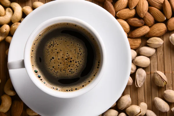 Coffee with nuts on background — Stock Photo, Image