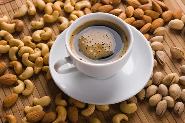 Kaffee mit Nüssen im Hintergrund — Stockfoto