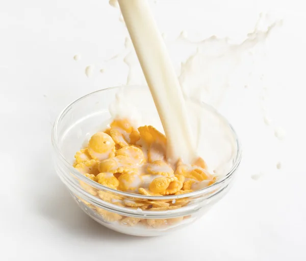 Mleko płynie na miskę płatków kukurydzianych — Zdjęcie stockowe