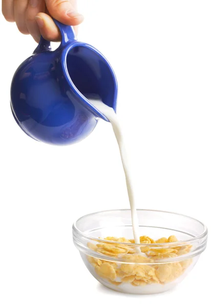 Milch fließt auf einer Schüssel Cornflakes — Stockfoto
