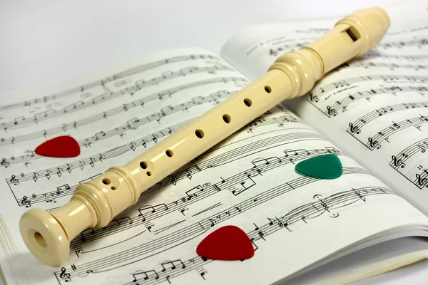 Flauta deitada na folha de notas — Fotografia de Stock