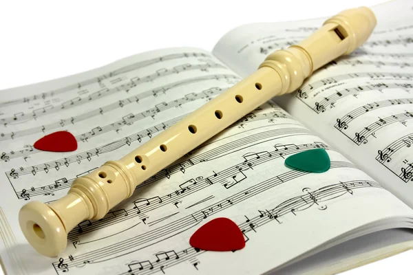 Flauta acostada en hojas de notas —  Fotos de Stock