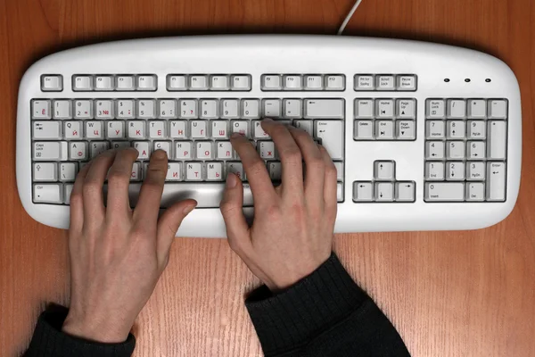 Teclado de ordenador con las manos en él — Foto de Stock