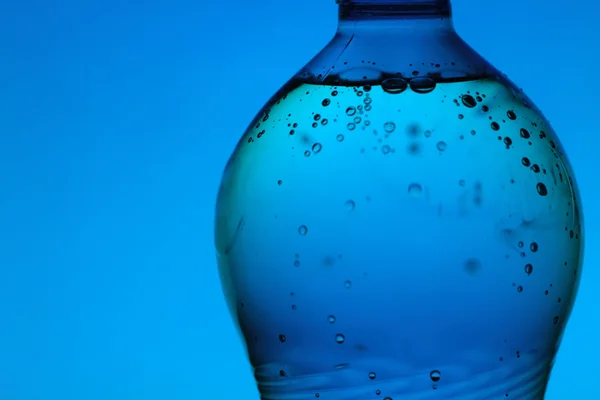 Garrafa de água mineral no fundo azul — Fotografia de Stock