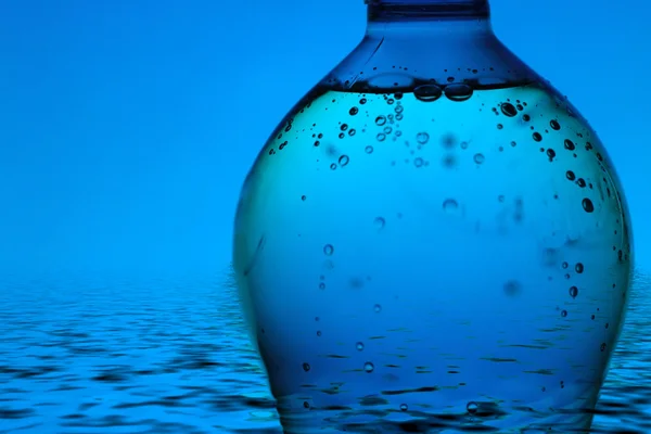 青い背景のミネラルウォーターボトル — ストック写真