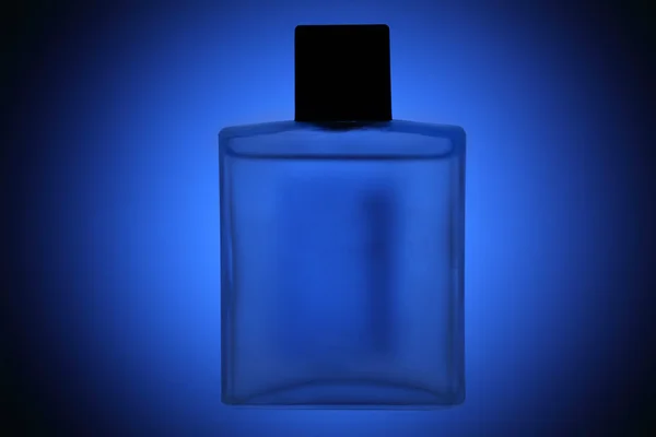 Frasco de perfume sobre fundo azul — Fotografia de Stock