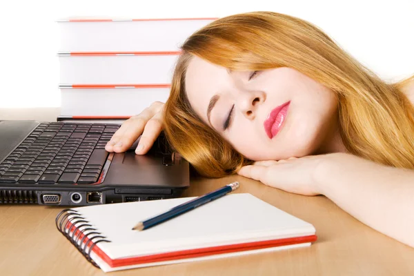 年轻女子睡在她的工作场所 免版税图库照片