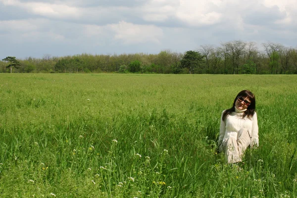Молода жінка лежить на зеленій траві — стокове фото