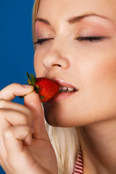 Menina bonita degustando um morango — Fotografia de Stock