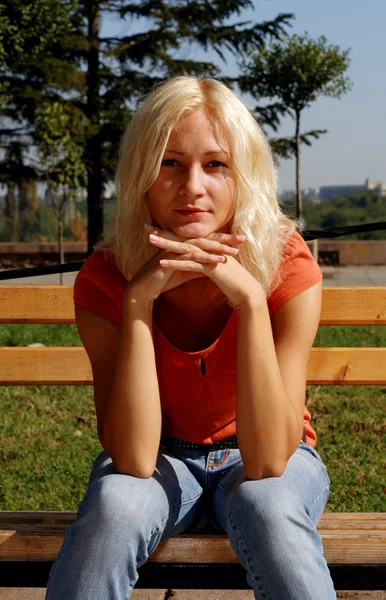 Vacker flicka i en park, titta på kameran — Stockfoto