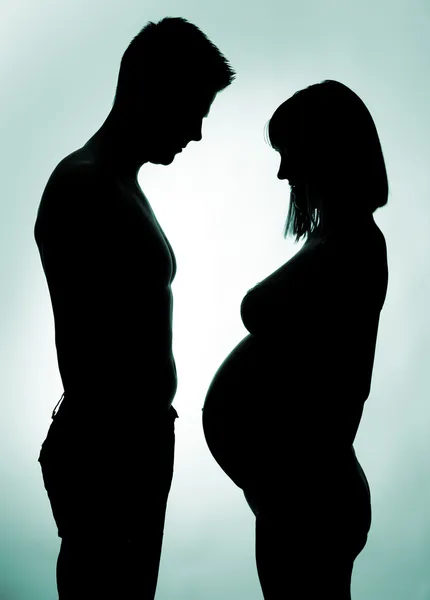 Silhouette di una giovane coppia in attesa di un bambino — Foto Stock