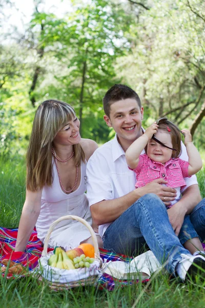 Молодая семья из трех человек на пикнике — стоковое фото