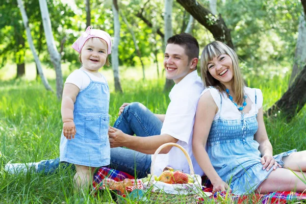 Mladá rodina ze tří na piknik — Stock fotografie