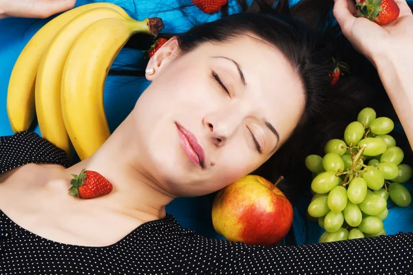 Krásná mladá žena s hromadou ovoce — Stock fotografie