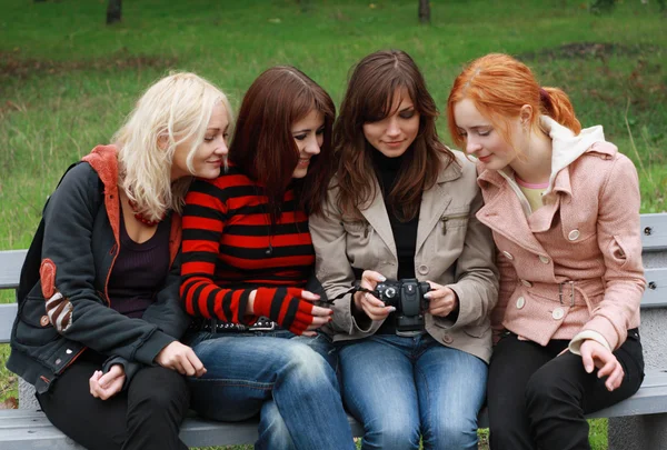 Quatro meninas se divertindo com uma câmera digital — Fotografia de Stock