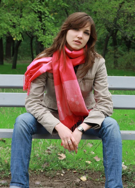 Girl sitting on a park bench — Stock Photo, Image