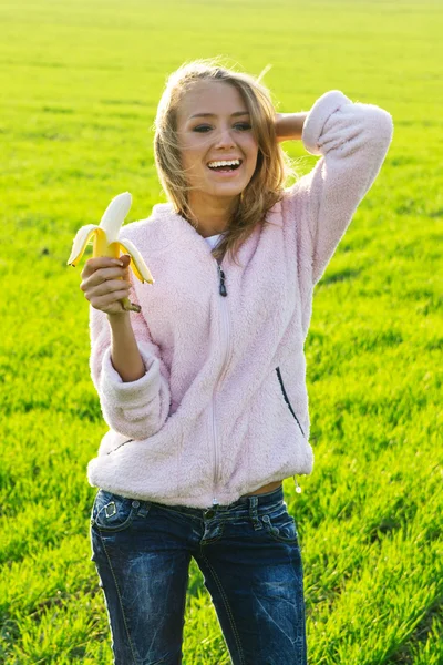 Junge Frau isst eine Banane — Stockfoto