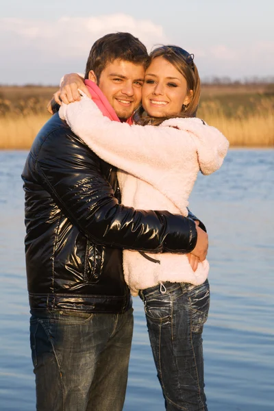 Yougn beautiful couple on a river bank — Stock Photo, Image