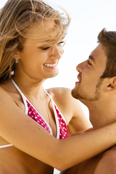 Молодая веселая пара веселится на пляже — стоковое фото