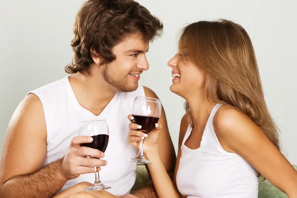 Веселая молодая пара пьет вино — стоковое фото