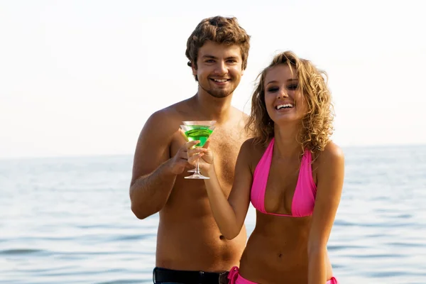 Νεαρό ζευγάρι στην παραλία, με κοκτέιλ — Φωτογραφία Αρχείου