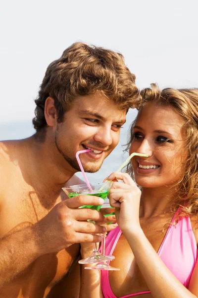 年轻的夫妇在海边与鸡尾酒 — 图库照片