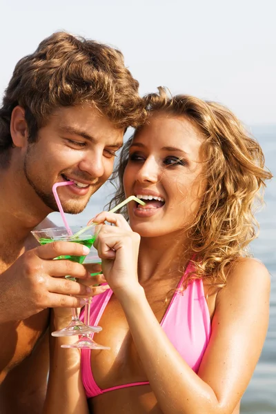年轻的夫妇在海边与鸡尾酒 — 图库照片